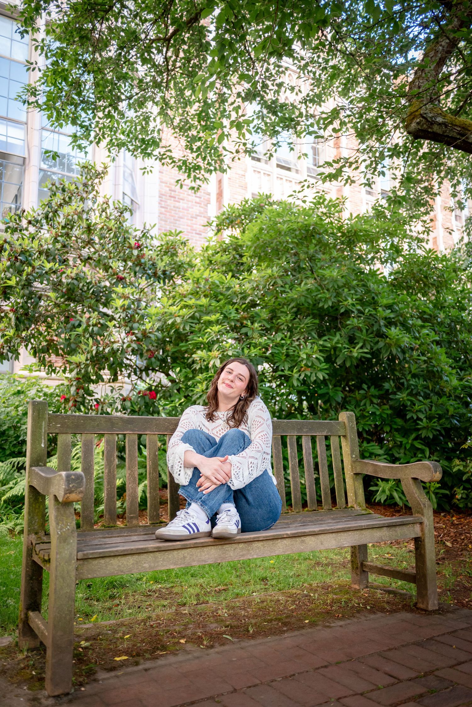 Graduate sitting on a bench in the University of Washington Quad