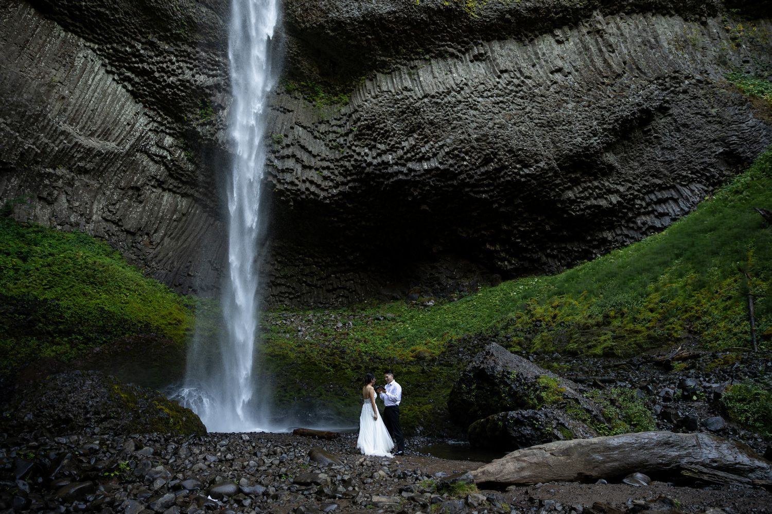 Bride and groom sitting on rocky terrain during elopement in Mount Rainier National Park.