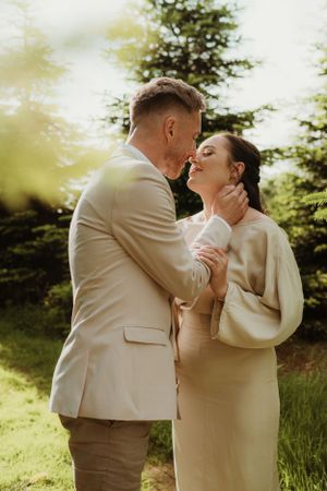 A romantic wedding photoshoot sequence showing a couple in cream-colored outfits embracing outdoors in natural lighting.