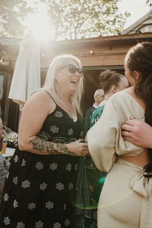 Wedding celebration sequence showing guests embracing in outdoor setting with natural lighting.