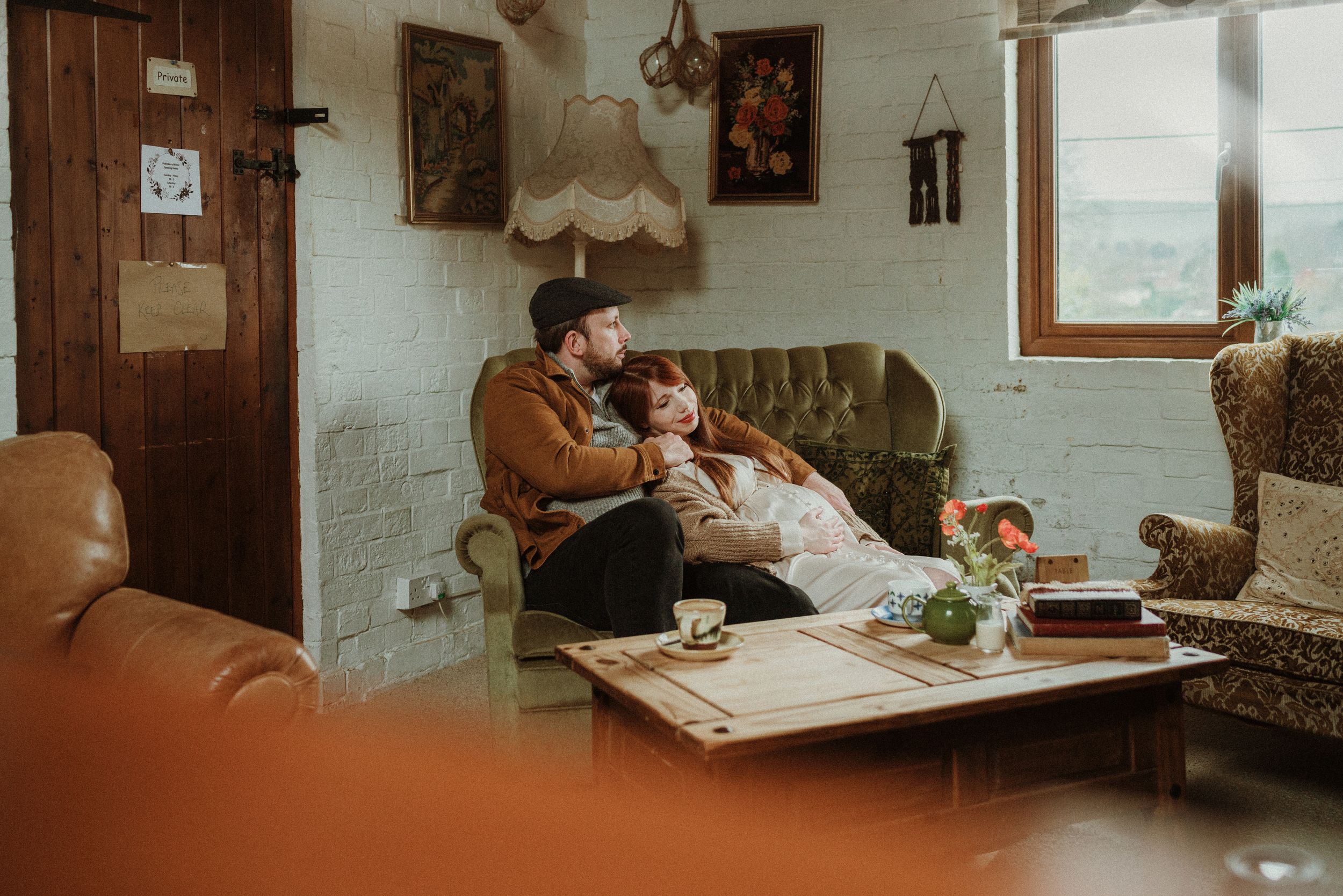 Couple enjoying coffee together at a cozy cafe table in warm lighting.
