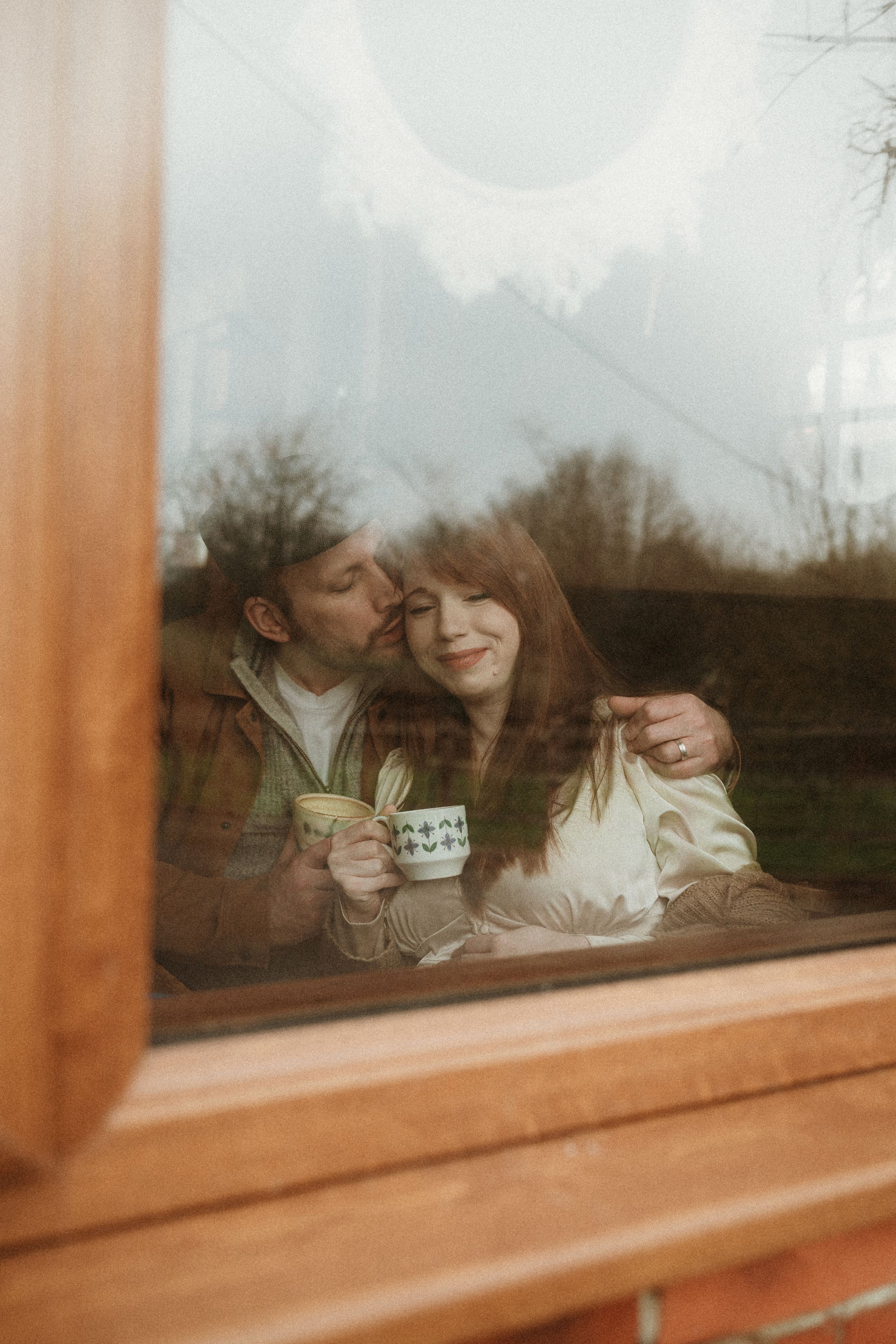 Romantic coffee date viewed through a window with natural light.