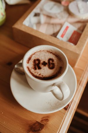 A series of coffee cups with decorative latte art designs on wooden table.