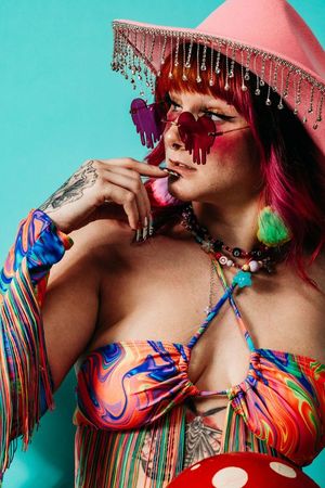 Artistic fashion photography with colorful fringe details and vibrant patterns against turquoise background. boudoir photography in studio