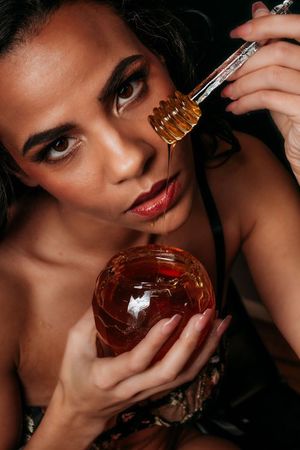 A luxurious perfume bottle held elegantly against a dark background in multiple artistic poses. boudoir photography in studio