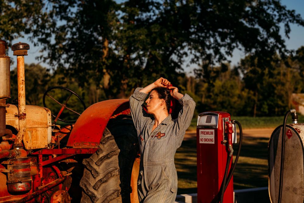 Rustic outdoor scene with vintage tractor and gas pump at golden hour. Boudoir Photography Studio, Grand Rapids MI