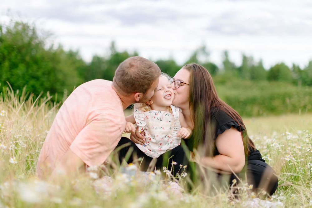 Family sharing an intimate moment together in a blooming wildflower field.