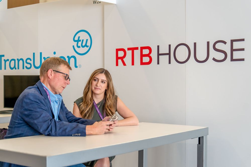 Modern office space with RTB House logo and TransUnion branding on white wall.