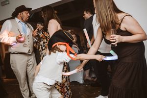 Wedding guests gather in a dark reception venue with drinks and conversation flowing at a celebratory event.