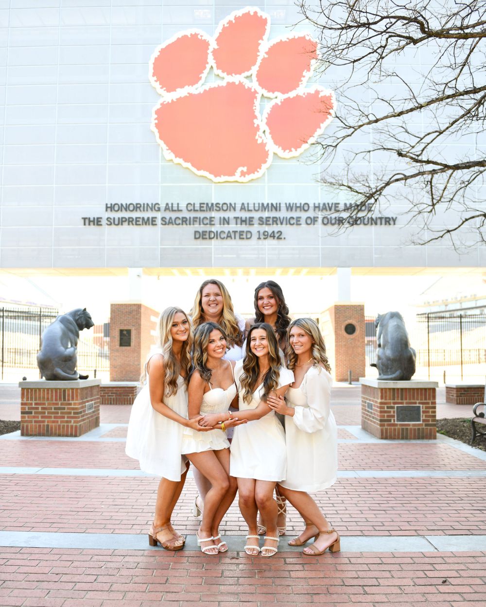 Group photo in front of the Clemson Memorial tiger paw sculpture and brick memorial wall.