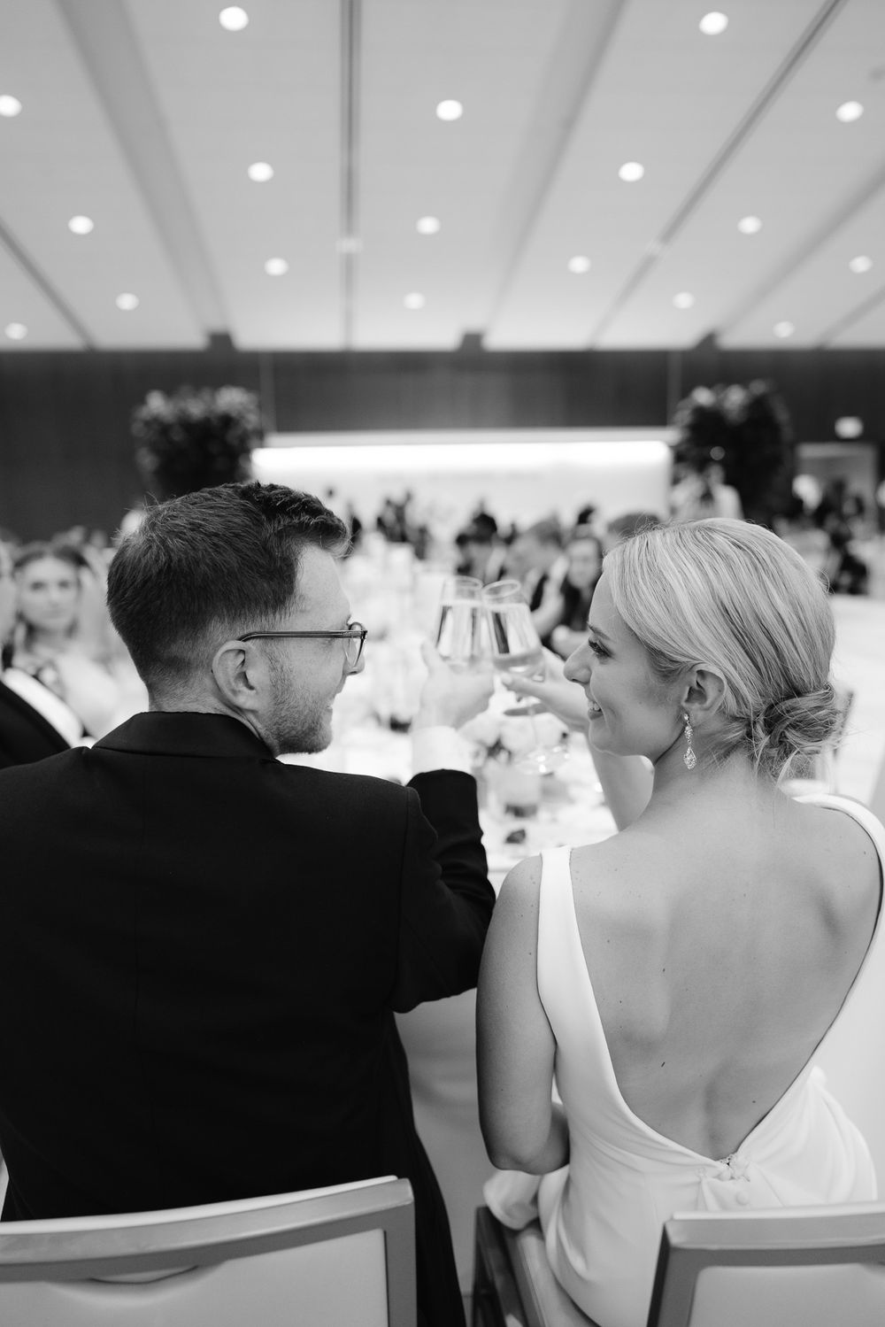 Bride and groom raising their champagne glasses in a celebratory toast at Bradley Symphony Center