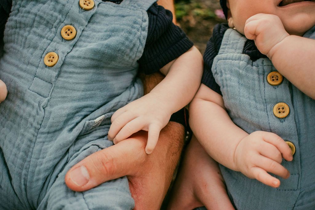 Mama holding twin newborns during Sarasota home session