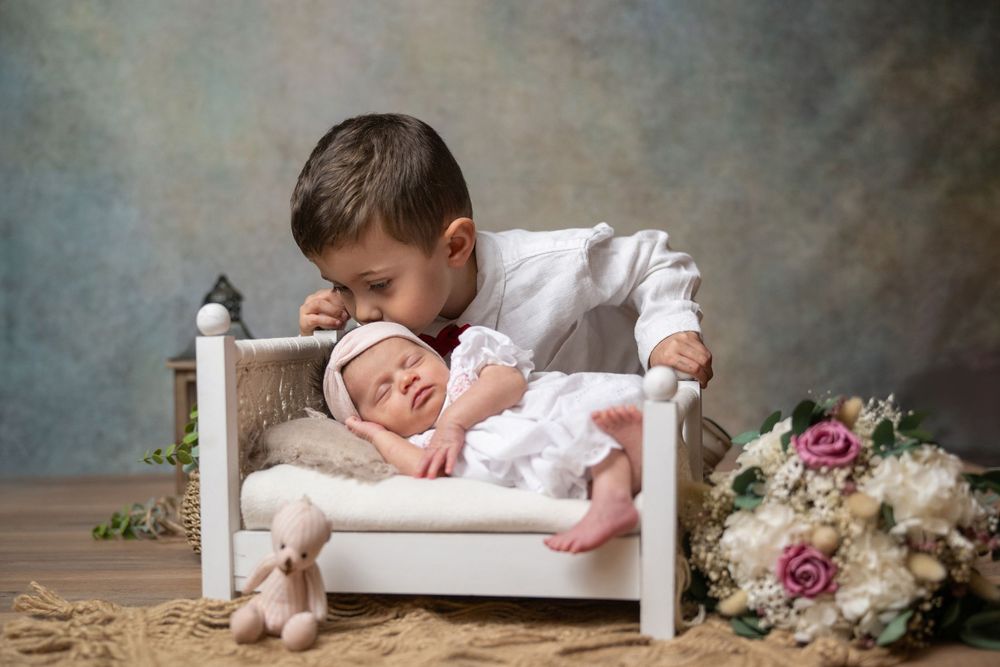 A series of soft, dreamy newborn photography portraits with vintage styling and floral arrangements on a textured backdrop.