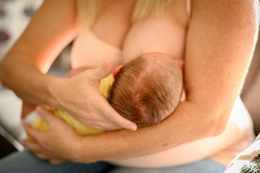 Tender moment of mother nursing newborn baby. Lifestyle newborn photoshoot in Las Vegas. Lifestyle Newborn photography Las Vegas.