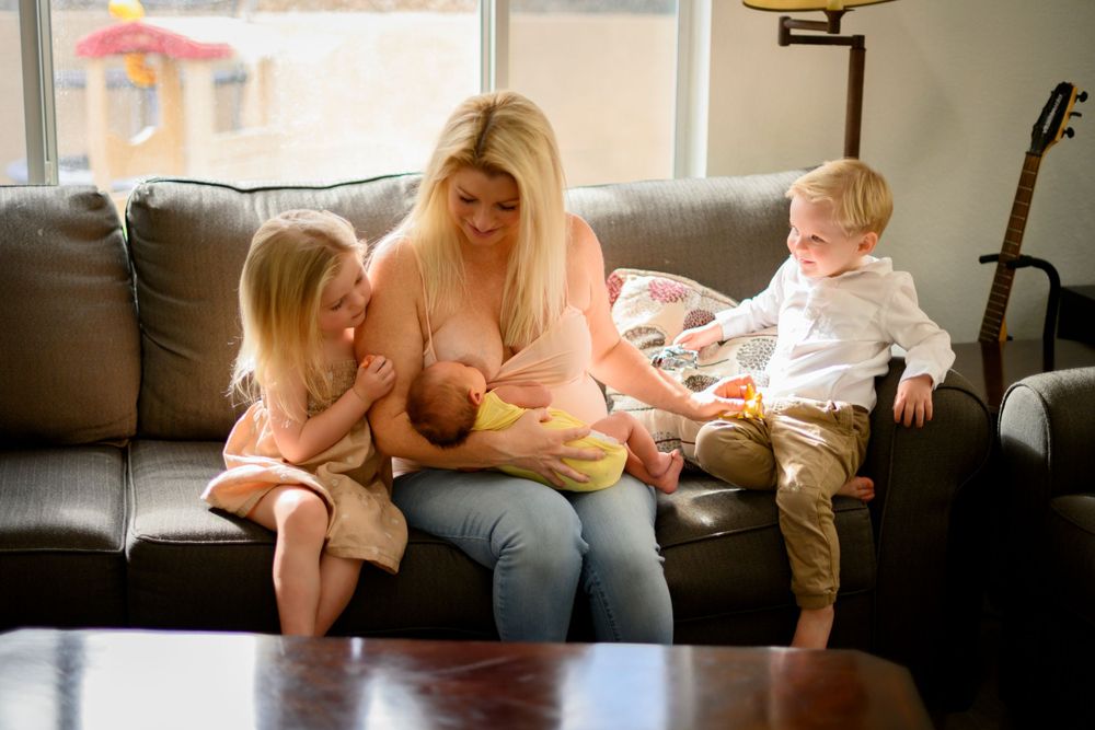 Mom nursing and bonding with children in natural light. Lifestyle newborn photoshoot in Las Vegas. Lifestyle Newborn photography Las Vegas.