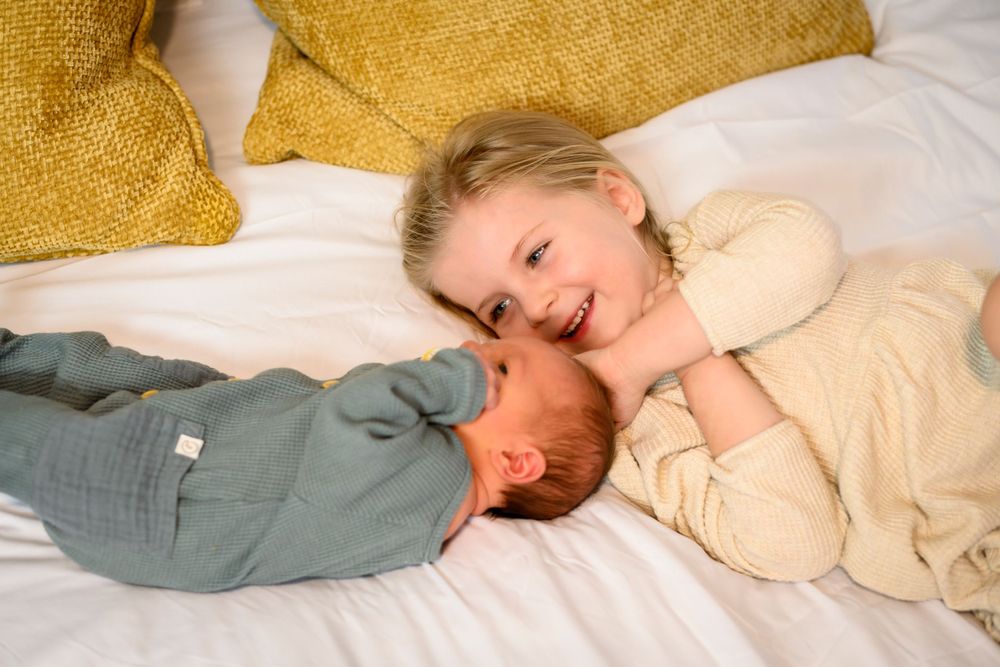 Siblings sharing tender moments on in home. Lifestyle newborn photoshoot in Las Vegas. Lifestyle newborn photographer Las Vegas.