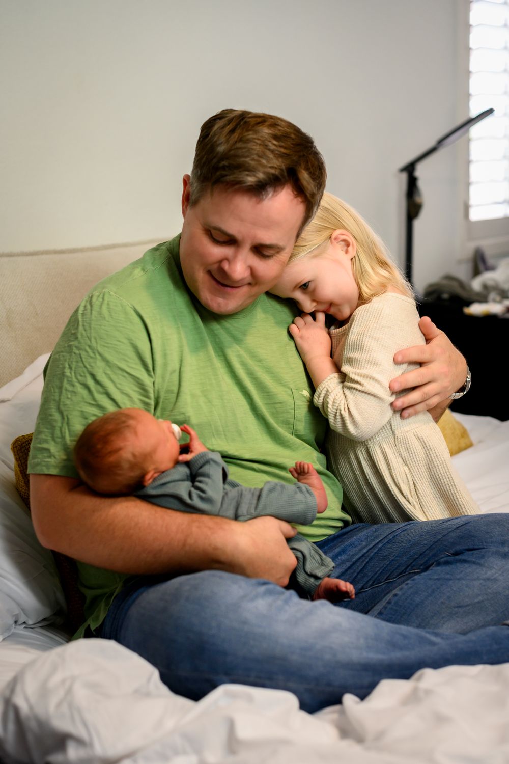 Family photo of father holding his daughter and newest member of the family. Lifestyle newborn photoshoot in Las Vegas. Newborn photographer