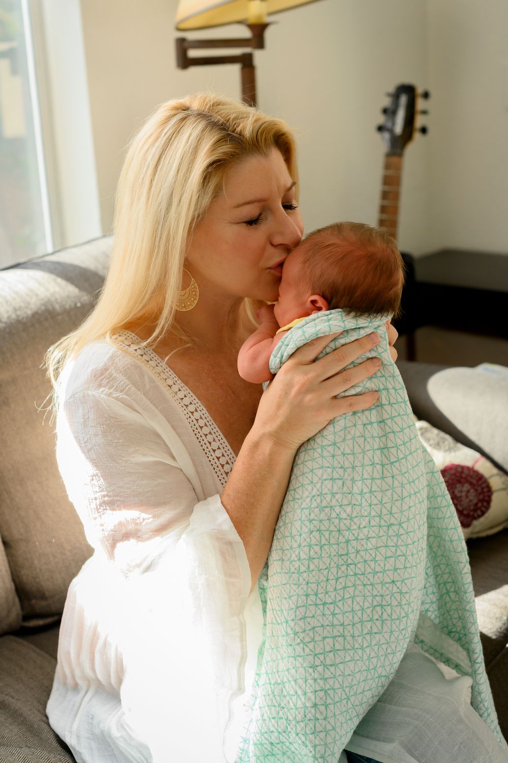 Mother gently kisses baby for a lifestyle newborn photoshoot. Lifestyle newborn photoshoot in Las Vegas. Lifestyle Newborn photographer.