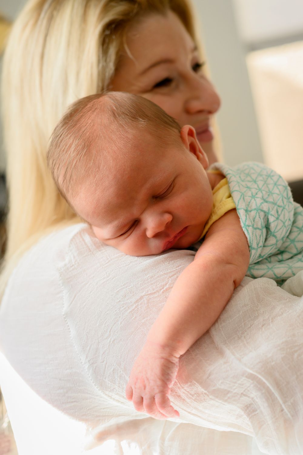 Peaceful newborn baby sleeps on parent's shoulder. Lifestyle newborn photoshoot in Las Vegas. Lifestyle Newborn photographer Las Vegas.