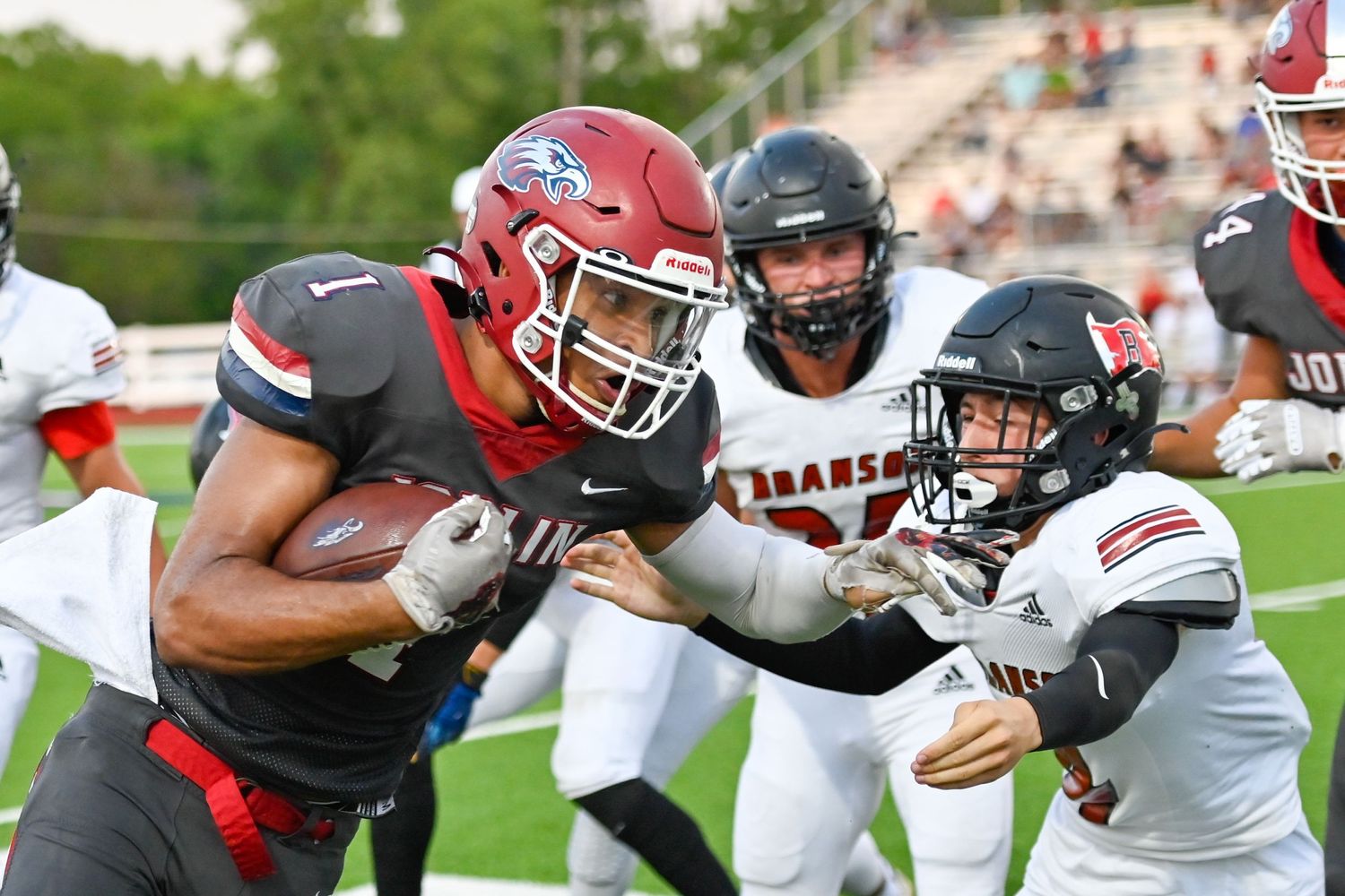 Football players clash during an intense game play with one carrying the ball.