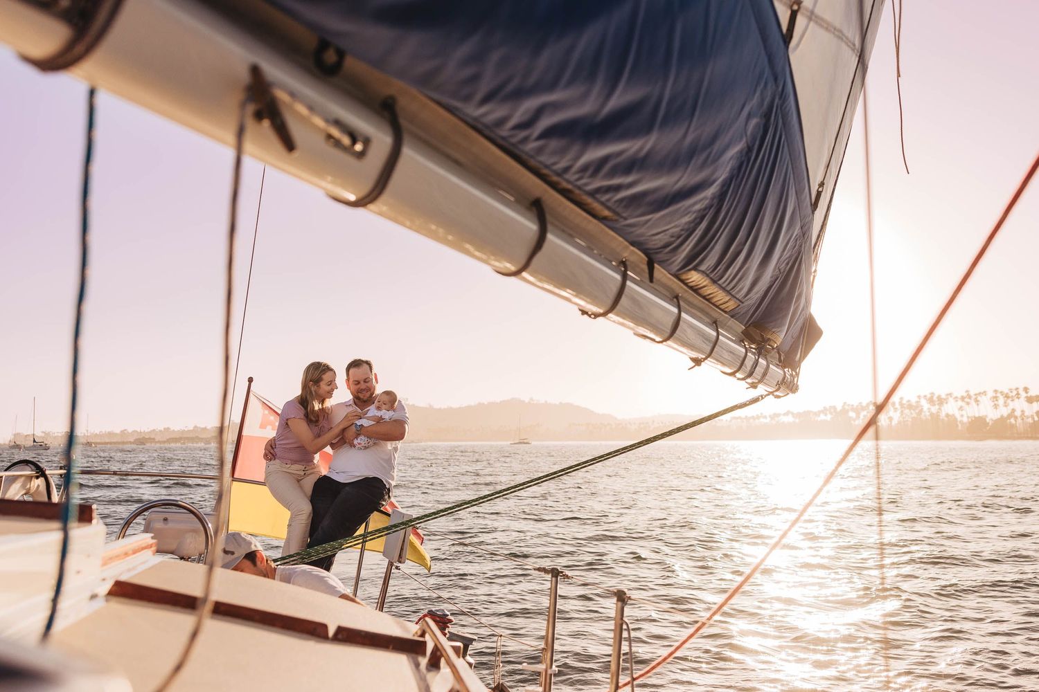 Sailboat adventure with scenic mountain coastline views at dusk.
