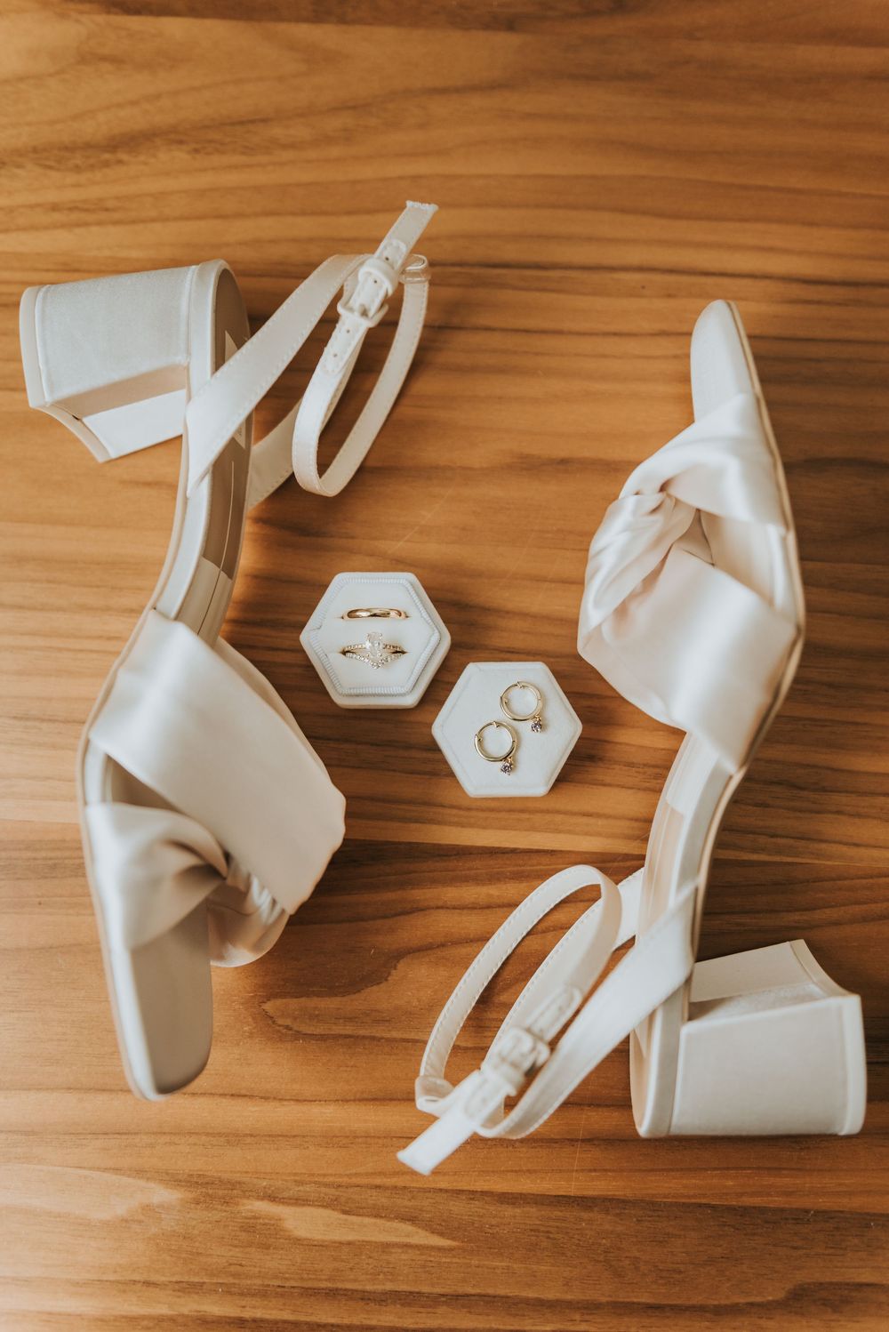 White geometric 3D printed shapes and components scattered on a wooden surface showing progressive assembly stages.