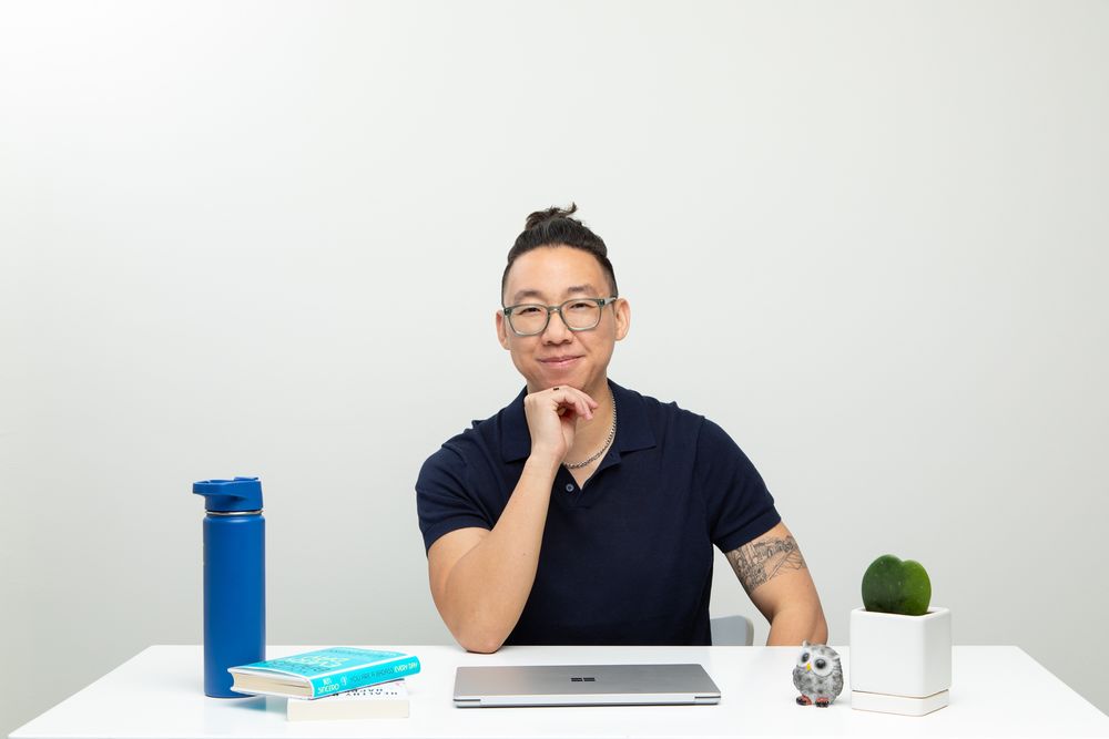 Portrait of man at white desk facing the camera