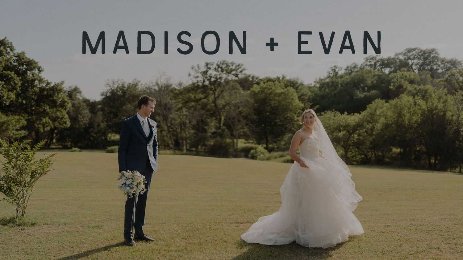 An intimate wedding portrait through a delicate veil in a lush garden setting.
