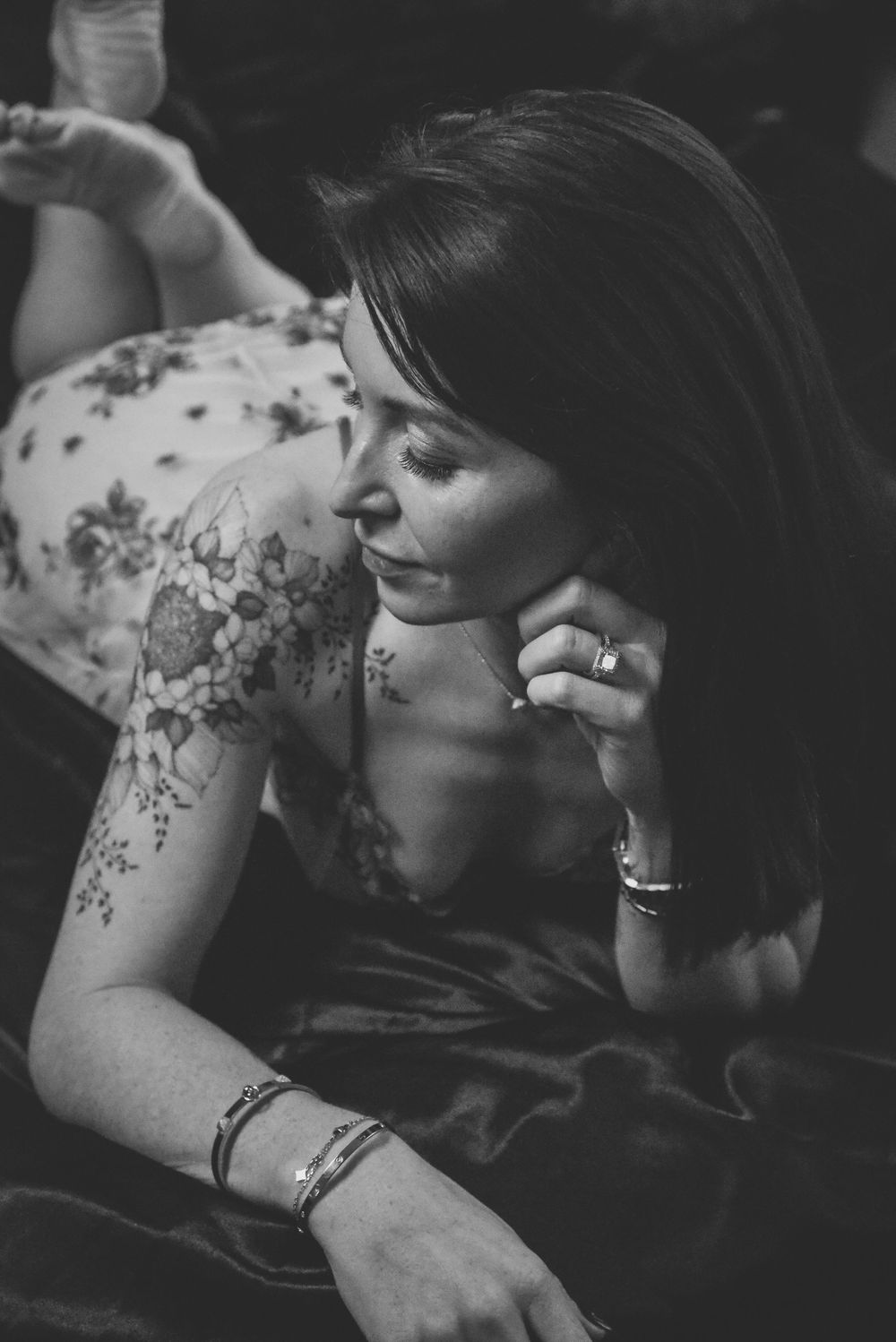 Black and white artistic portrait showing delicate floral tattoo details.