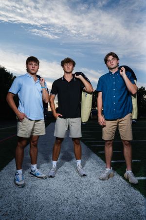 Group photo on white painted lines of a sports field at dusk.