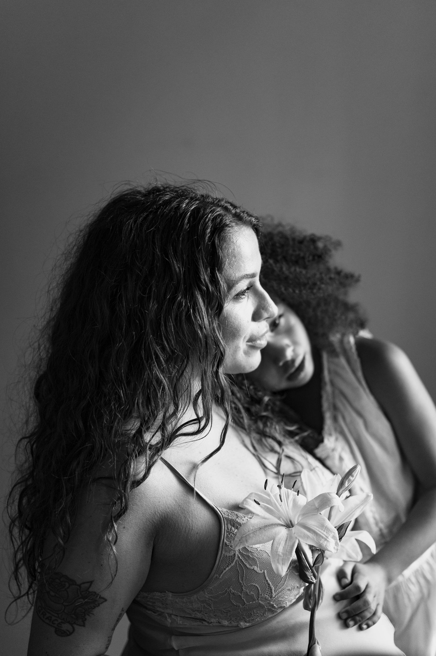 Intimate black and white boudoir portrait showcasing natural lighting and delicate lace details.