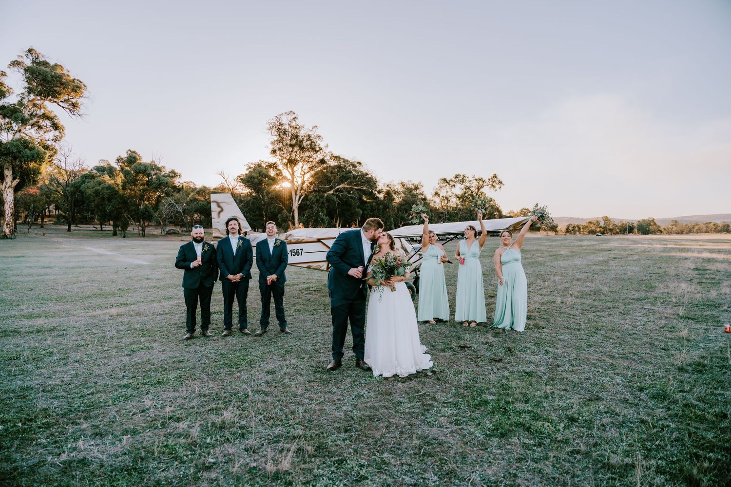 Panoramic view of a rustic outdoor wedding ceremony with trees and natural landscape.
