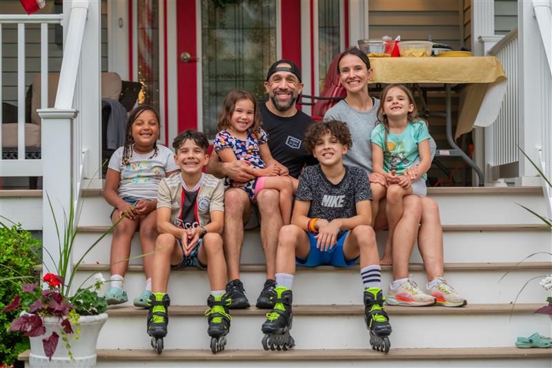 Friends gathered on front porch steps for casual group photo.
