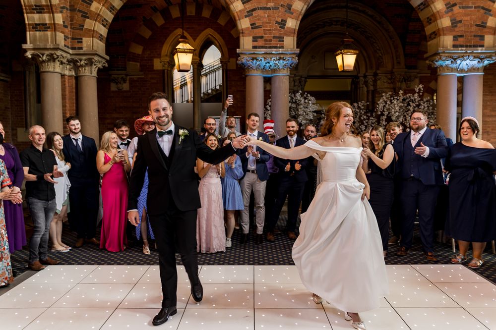 Wedding celebration with dancing couples in elegant ballroom setting.