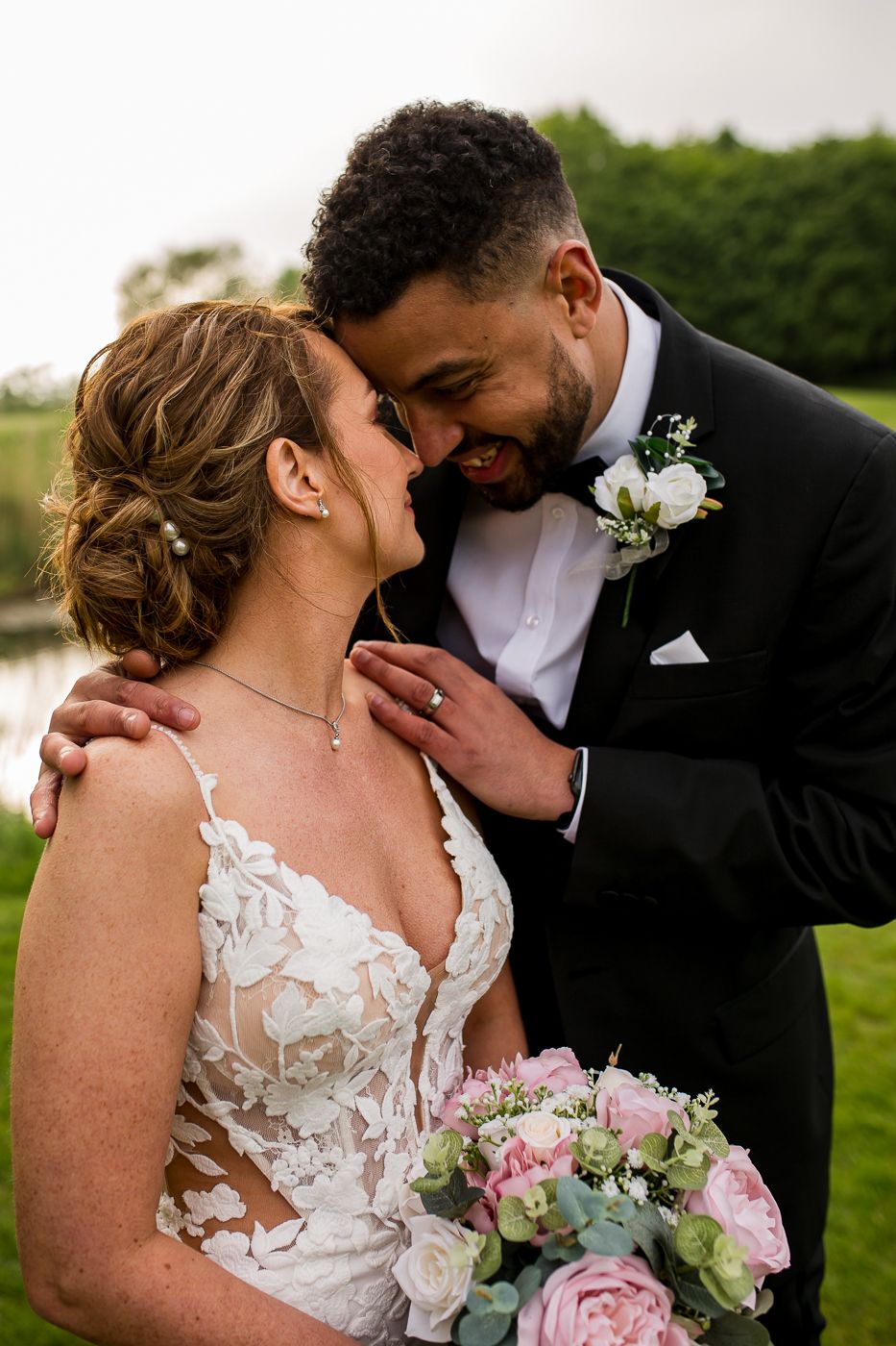 Romantic wedding portraits featuring delicate lace dress details and pink floral bouquet.