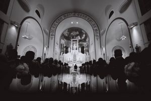Black and white photo of church interior with dramatic arched ceiling and altar.