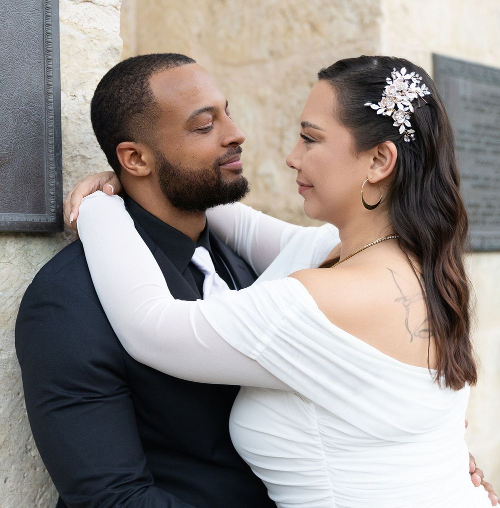 A romantic wedding couple embraces against a stone wall in a series of intimate portrait poses.