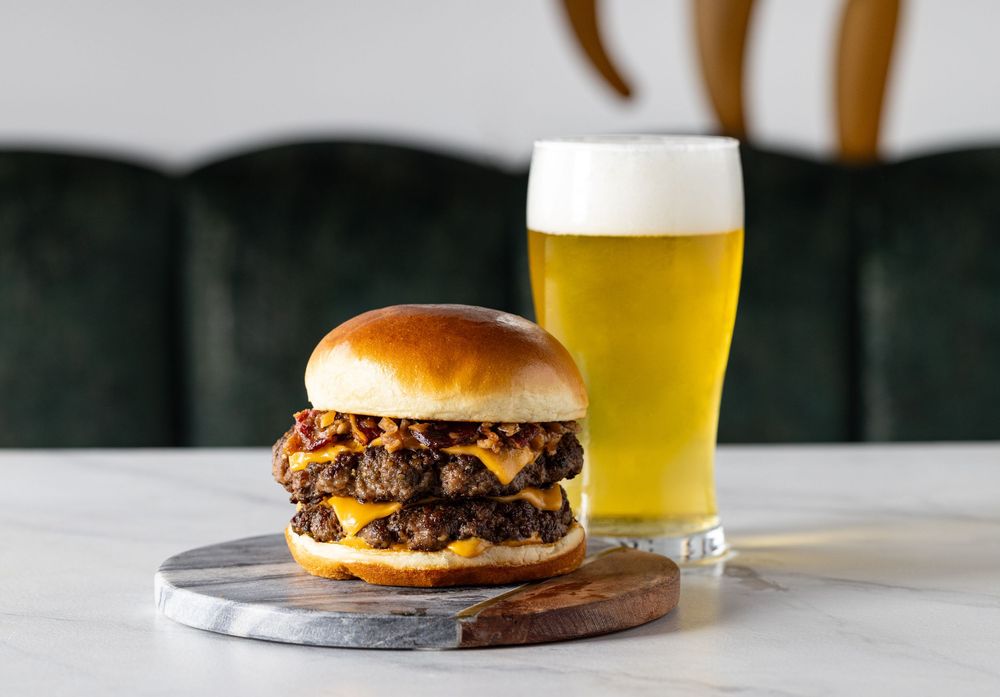 Double cheeseburger served with a glass of beer served in a sports arena captured by LA food photographer.