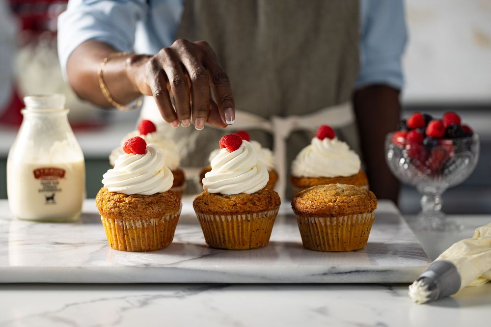 Food lifestyle photograph of a woman decorating cupcakes captured in Los Angeles photography studio.