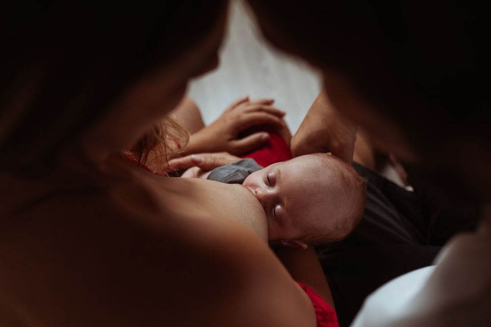 Artistic dark and moody newborn photography session with parents.