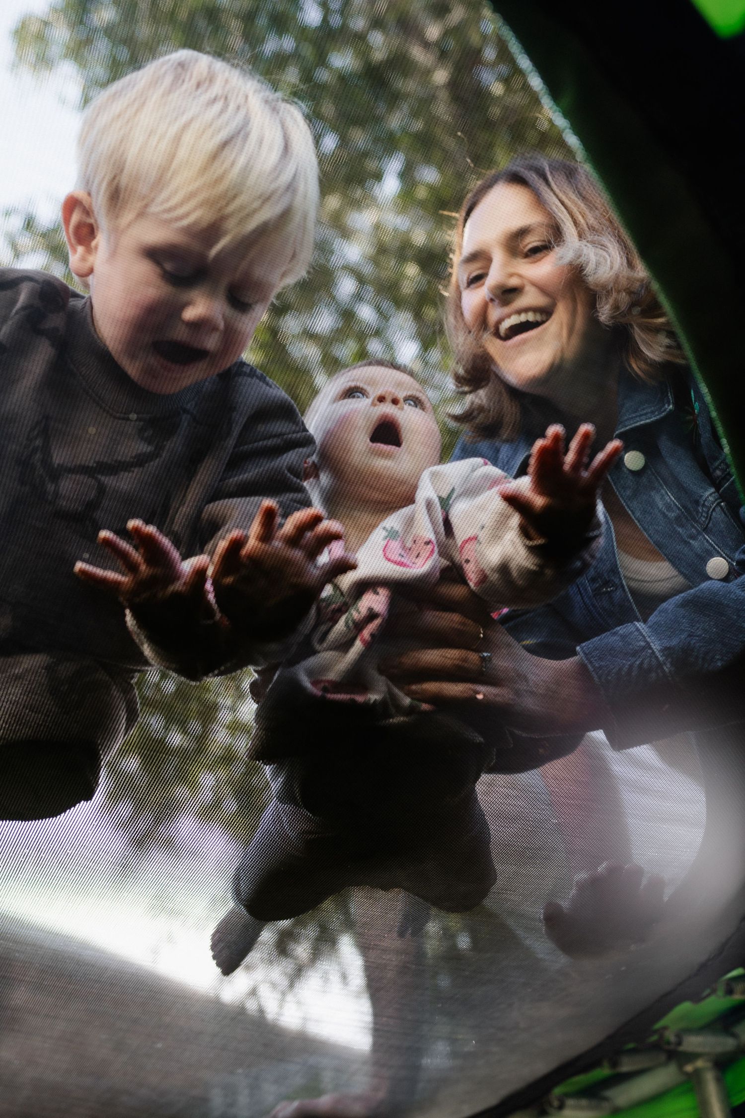Mother, Father and newborn baby cuddling in the backyard of their home