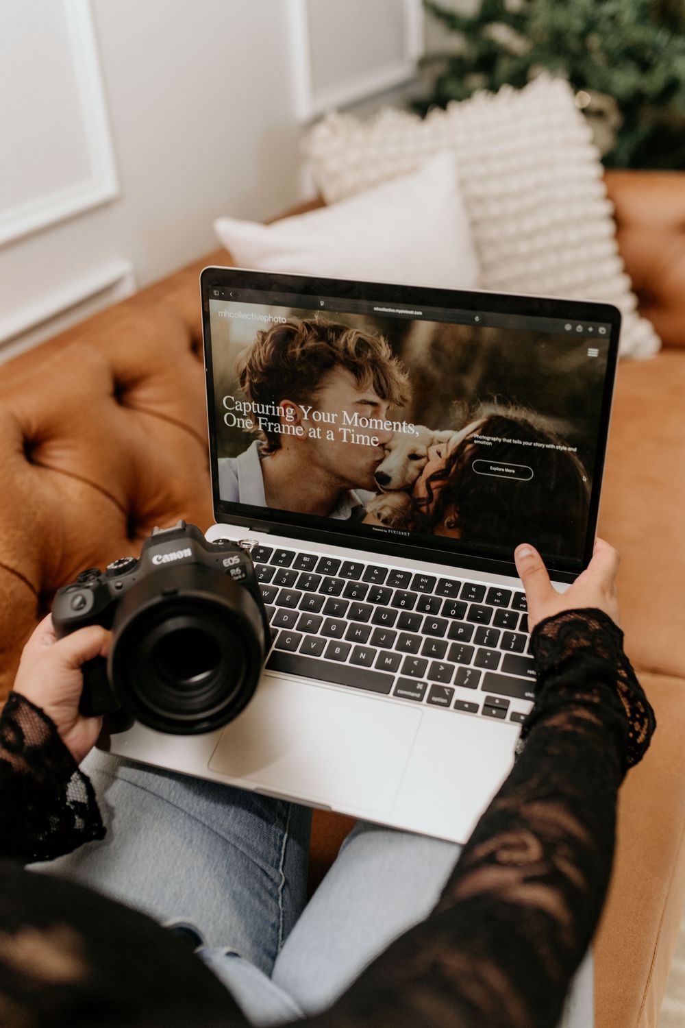 Laptop and headphones on brown leather couch showing website interface.
