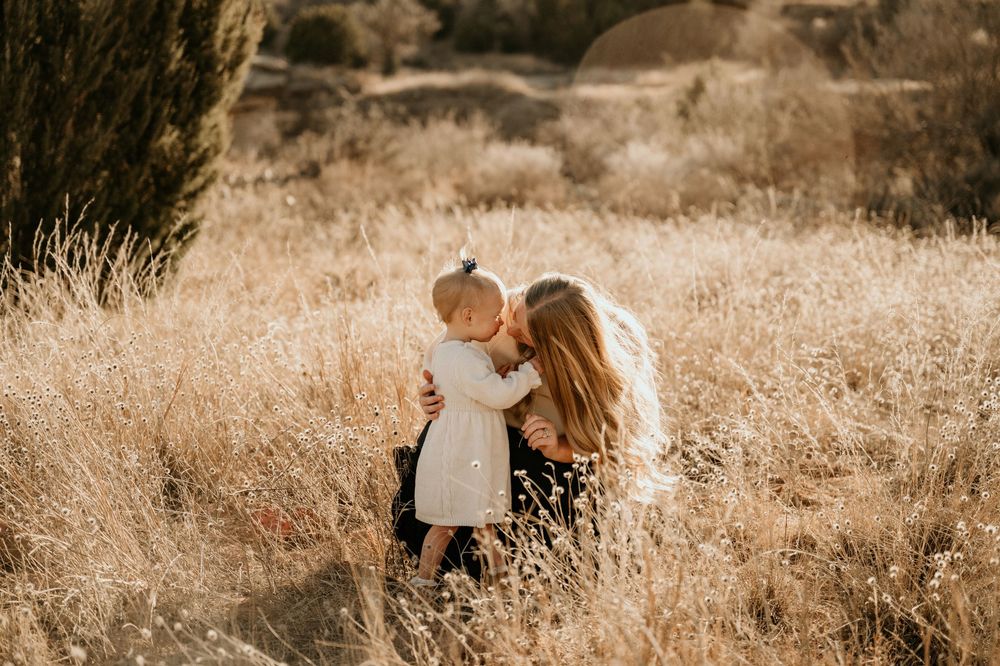 Intimate couple photoshoot in a sun-drenched field with warm sepia tones.