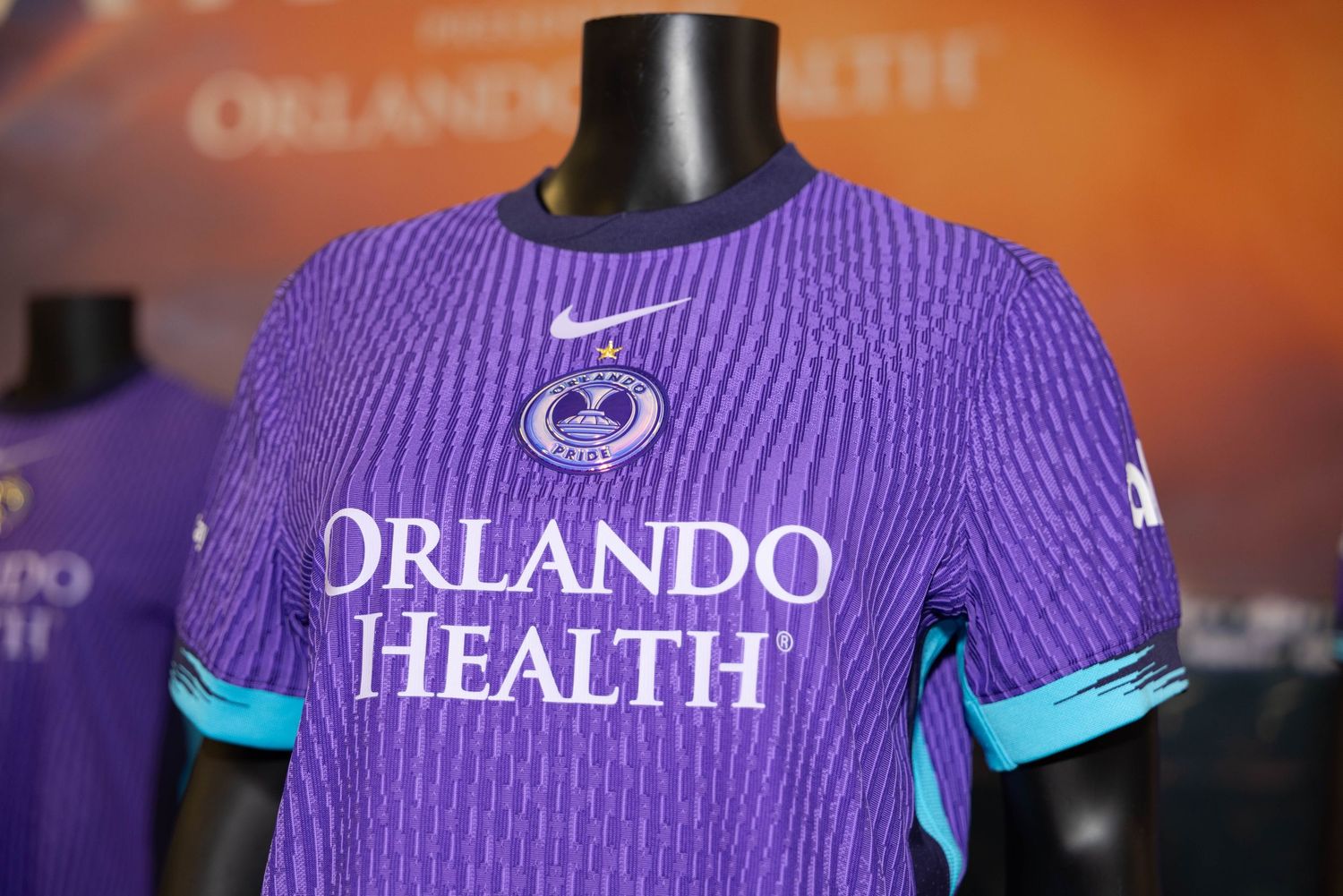 Display of purple and turquoise sports jerseys with Orlando Health branding.