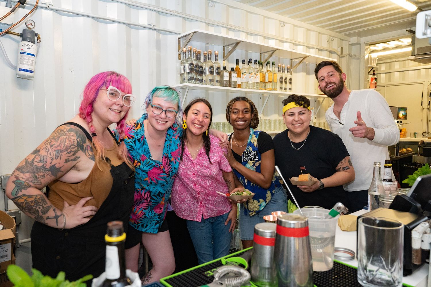 Group of people gathered at a lively social event with colorful decorations and festive atmosphere.