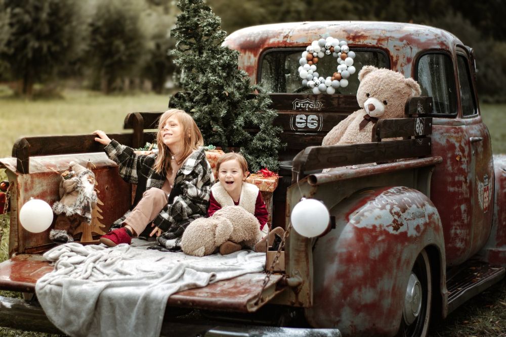 Mini-session photo de Noël 2022 avec un pick-up vintage américain, décoré pour les fêtes, créant une ambiance festive et rétro.