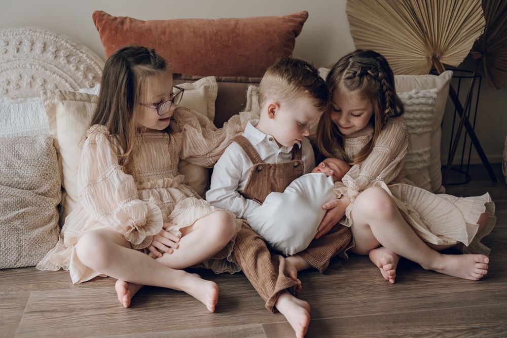 Family members share intimate moments while relaxing on light colored bedding.