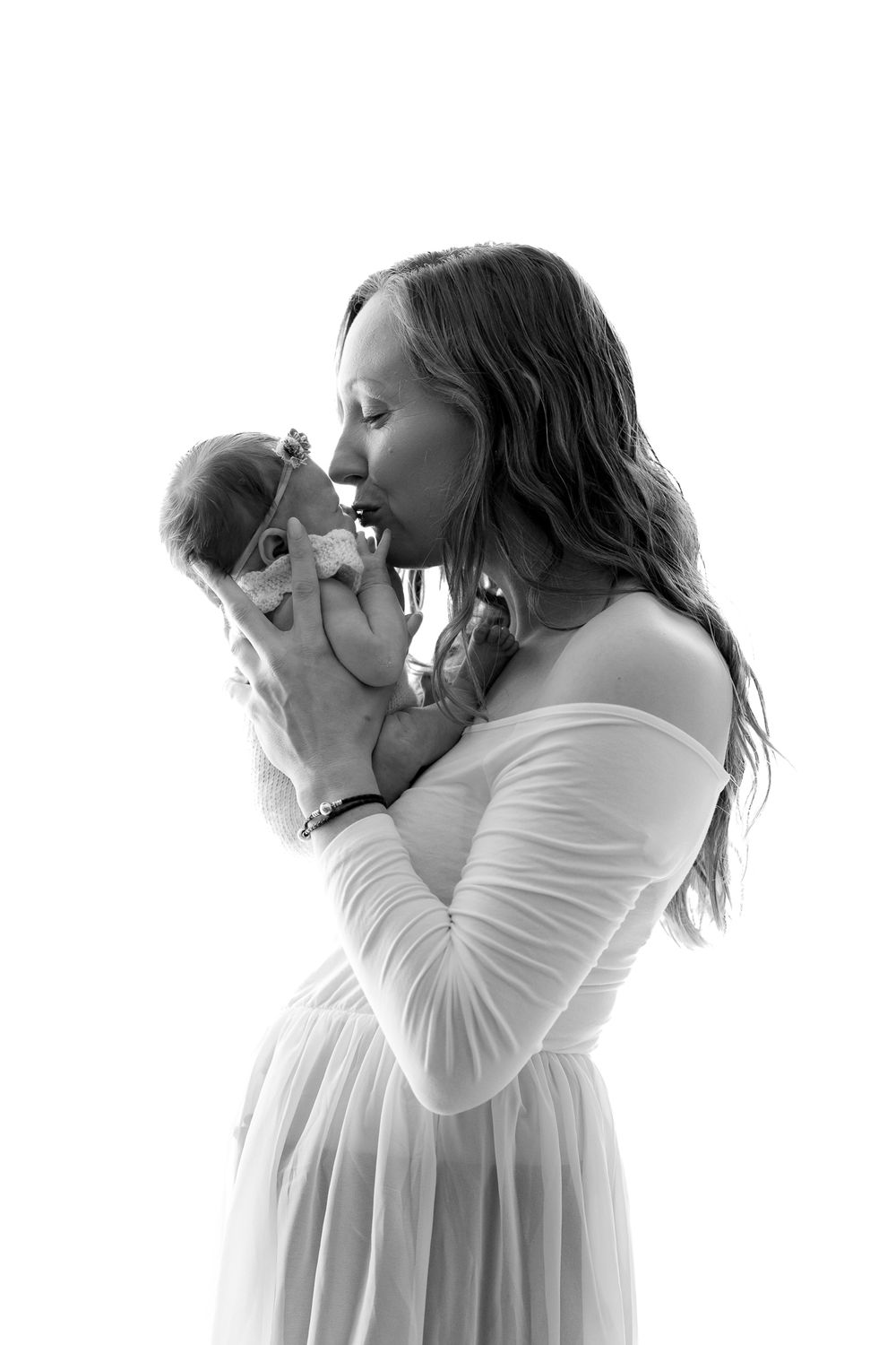 Black and white portrait of tender moment between parent and newborn.