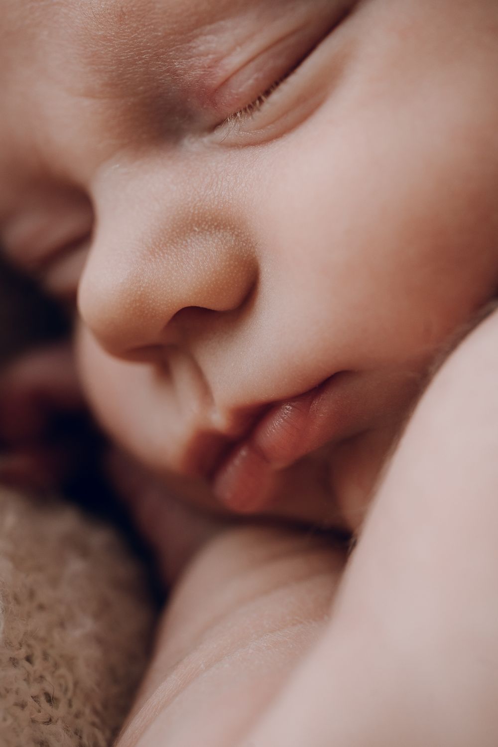 Close-up profile of a sleeping newborn with delicate features.