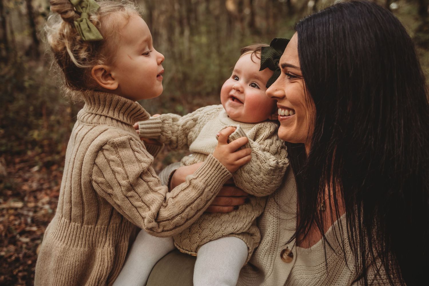 A heartwarming outdoor family moment captured in warm autumn tones as three people share joyful laughter together.